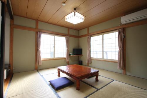 salon ze stołem i 2 oknami w obiekcie Nozawaonsen Yamayasanso w mieście Nozawa Onsen