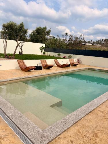 a swimming pool with lounge chairs in a backyard at Refúgio D'Aldeia in Leiria