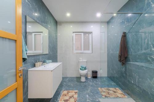 a bathroom with a toilet and a sink and a mirror at New Spacious Apartment 3 Bdr 2 Bth Bugibba 124 with View in St. Paul's Bay