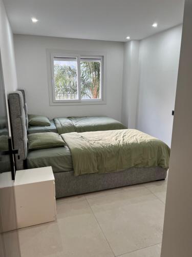 a bed and a couch in a room with a window at Apparemment Martil Sofia bay in Martil