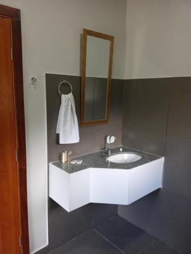 a bathroom with a white sink and a mirror at Pousada Casa Terra de Pinheiros in Santo Antônio do Pinhal