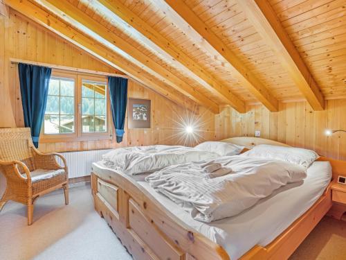 a large bed in a room with a wooden ceiling at Alpenchalet mit Charme in Lenk
