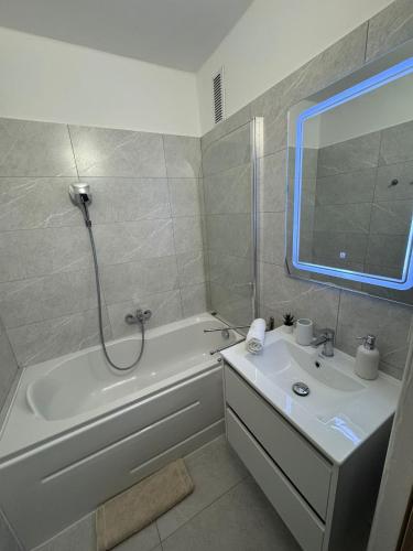 a bathroom with a white tub and a sink and a bath tub at Zora Apartman in Veszprém