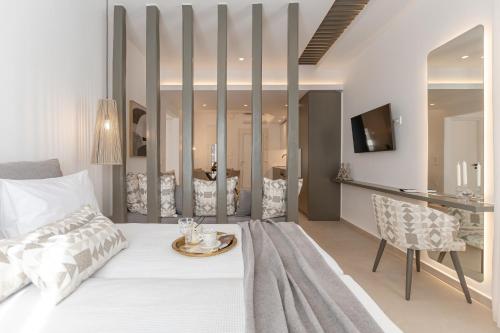 a bedroom with a white bed and a dining room at Rafaela Casa Luxury Apartment Naxos in Naxos Chora