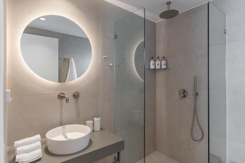 a bathroom with a sink and a shower with a mirror at Rafaela Casa Luxury Apartment Naxos in Naxos Chora
