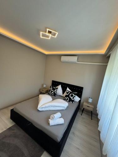 a bedroom with a bed with pillows on it at Zora Apartman in Veszprém