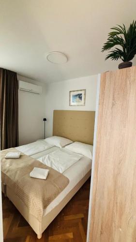 a bedroom with a large bed with two towels on it at Ava Apartments in Omišalj