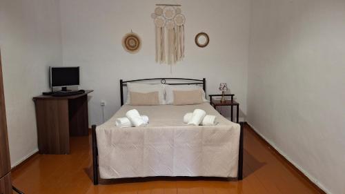 a bedroom with a bed with white sheets and pillows at Saint George Terrace House in Chios