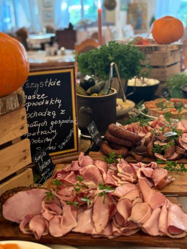 a table topped with meat and other meats and vegetables at Folwark Nadmorska Ostoja in Mechelinki