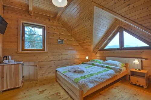 a bedroom with a bed in a wooden cabin at Pokoje Gościnne u Laskowskich in Smerek