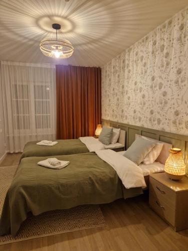 a bedroom with two beds and a chandelier at Raunex Apartment in Haapsalu