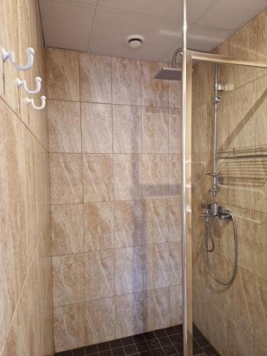 a shower with a glass door in a bathroom at Raunex Apartment in Haapsalu