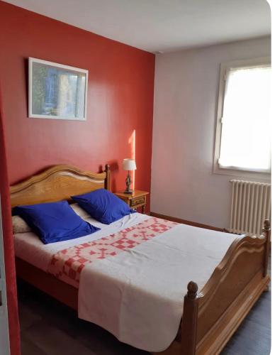 a bedroom with a bed with a red wall at Maison Treize vents in Treize-Vents