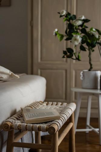 a book sitting on a stool in a room with a plant at Rooms Buonanotte Barbarossa in Prato