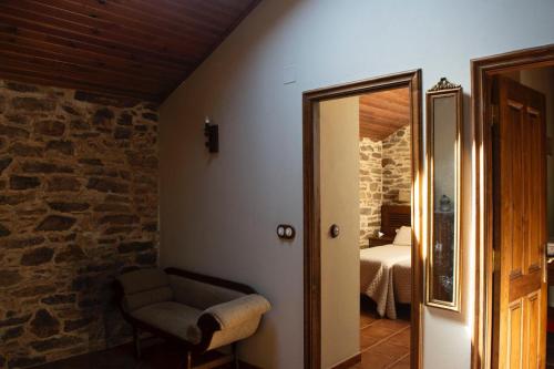 a room with a chair and a room with a bedroom at Casa rural osvilares in Santiago de Compostela