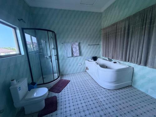 a bathroom with a shower and a tub and a toilet at Afranasa Inn in Tema