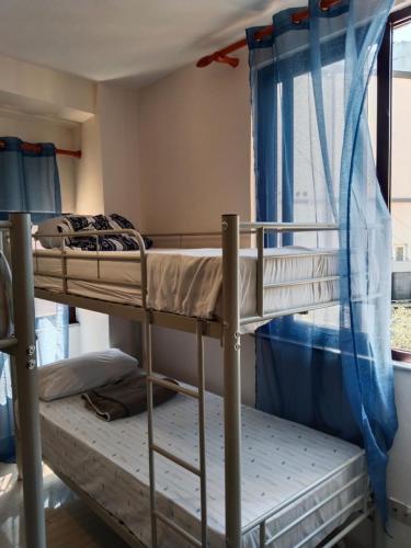 two bunk beds in a room with a window at Moon e Sky in Tirana