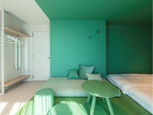a bedroom with a bed and a green wall at toggle hotel suidobashi - Vacation STAY 06279v in Tokyo