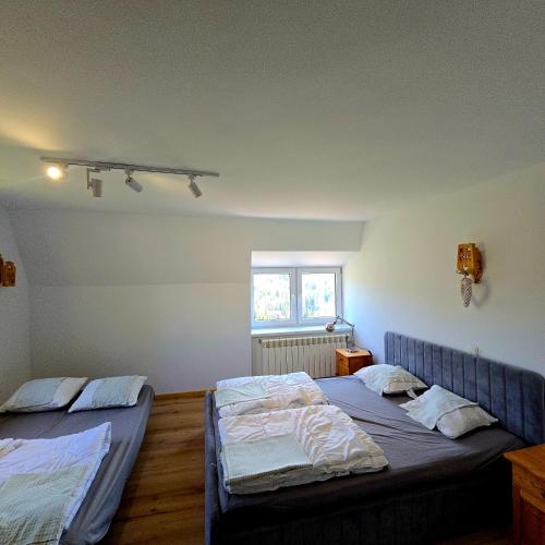 a bedroom with two beds and a window at Dom na Cieńkowie in Wisła