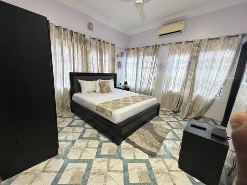 a bedroom with a bed in a room with curtains at Afranasa Inn in Tema