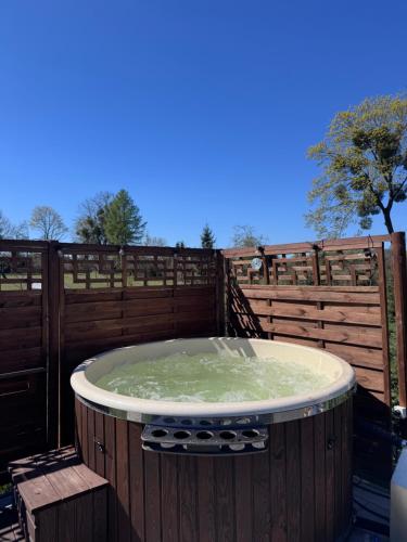 a large hot tub sitting on top of a fence at Domek na wzgórzu in Ukta
