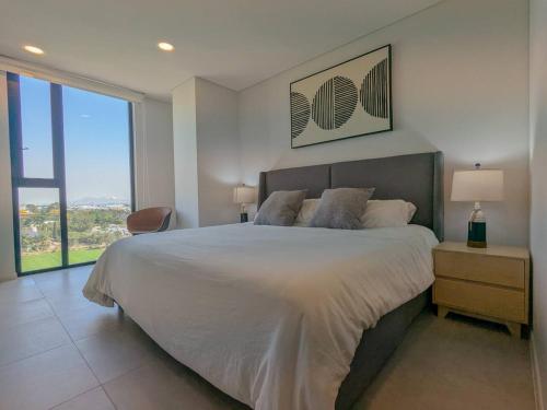 a bedroom with a large bed and a large window at (Luxury Apartment en Punto Sur in Los Gavilanes