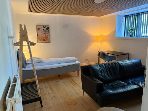 a living room with a bunk bed and a couch at Lille Skovgaarden ved parken med gratis parkering in Randers