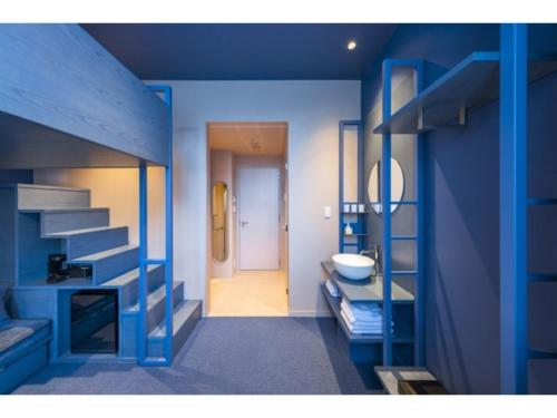 a blue room with a bunk bed and a bathroom at toggle hotel suidobashi - Vacation STAY 13439v in Tokyo