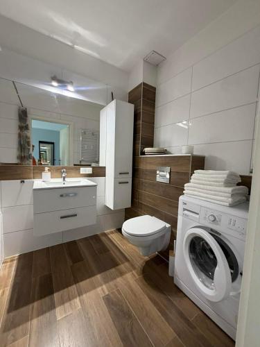a bathroom with a washing machine and a sink at Apartament Marco z balkonem in Oleśnica
