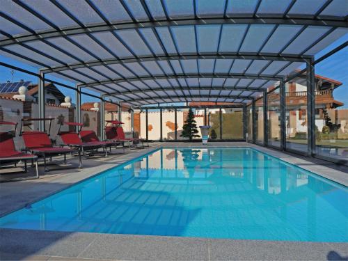 ein Schwimmbecken mit einer darüberliegenden Pergola in der Unterkunft Alluring Holiday Home in Ubersee with Whirlpool in Übersee