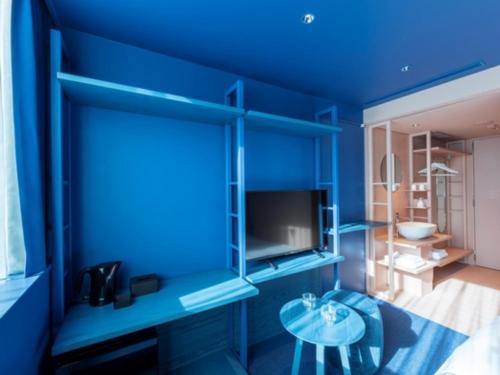 a blue room with a table and a blue wall at toggle hotel suidobashi - Vacation STAY 18195v in Tokyo