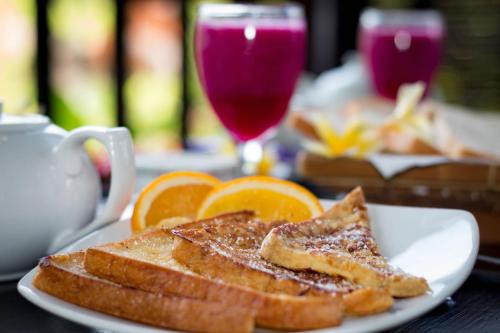 een bord met toast en sinaasappelschijfjes op tafel bij Tropical Bali Hotel in Sanur