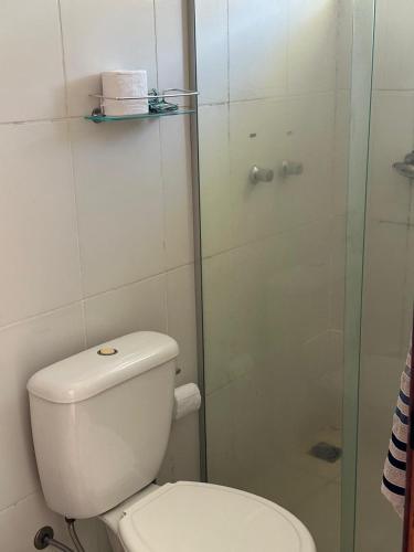 a bathroom with a toilet and a glass shower at Hospedagem Aconchego in Lagoa Santa