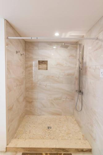 a bathroom with a shower with beige marble walls at Whispering Swan Bay Haven in Trenton