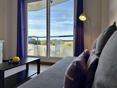 a living room with a couch and a view of a balcony at Duplex con vistas La Arena 4605 in Arnuero