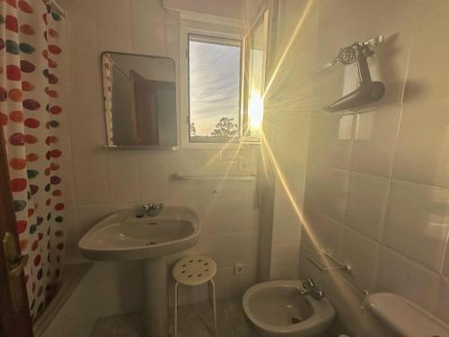 a bathroom with a sink and a toilet and a window at Duplex con vistas La Arena 4605 in Arnuero