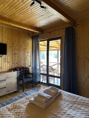 a bedroom with a bed and a sliding glass door at Вершина in Vorokhta