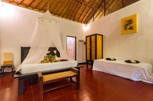 Cette chambre comprend 2 lits et une table à baldaquin. dans l'établissement Tropical Bali Hotel, à anur