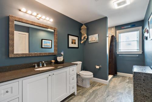 a bathroom with a toilet and a sink and a mirror at Point Judith Coastal Retreat in Narragansett