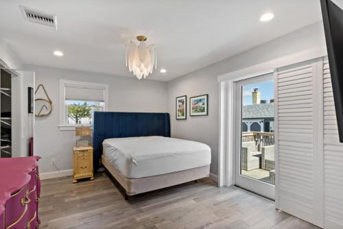 a bedroom with a bed and a sliding glass door at Point Judith Coastal Retreat in Narragansett