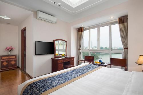 a bedroom with a large bed and a television at Lakeside Palace Hotel in Hanoi