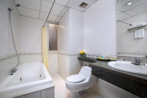 a white bathroom with a toilet and a sink at Lakeside Palace Hotel in Hanoi
