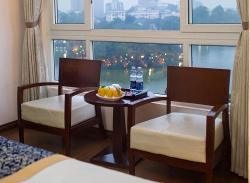 a room with a table and two chairs and a window at Lakeside Palace Hotel in Hanoi