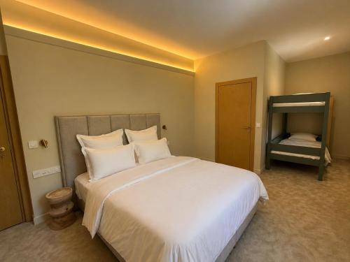 a bedroom with a large bed with white sheets and pillows at DomaineduRocBlanc in Merey