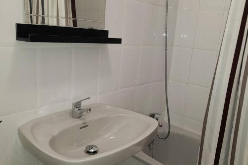 a white bathroom with a sink and a shower at La Arena 4410 in Isla