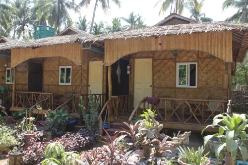 a house in the middle of a garden at Soe Ko Ko Beach House & Restaurant in Ngwesaung