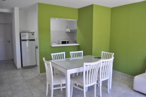 a kitchen with a table and chairs and green walls at Los Abus in Colón