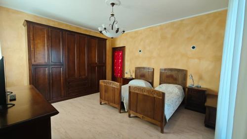 a bedroom with a bed and wooden cabinets and a table at B&B Gatto Rosso in Sandigliano
