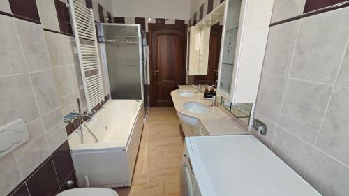 a bathroom with three sinks and a toilet and a tub at B&B Gatto Rosso in Sandigliano