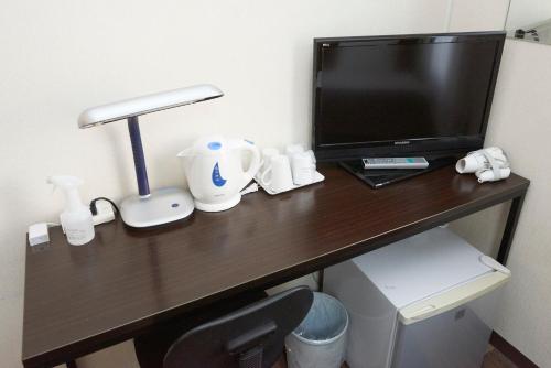 a desk with a television and a lamp on it at Hotel Select Inn Utsunomiya in Utsunomiya